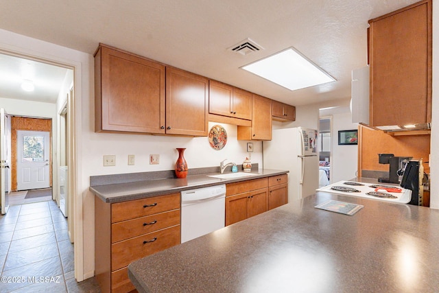 kitchen with sink, white appliances, and tile patterned floors