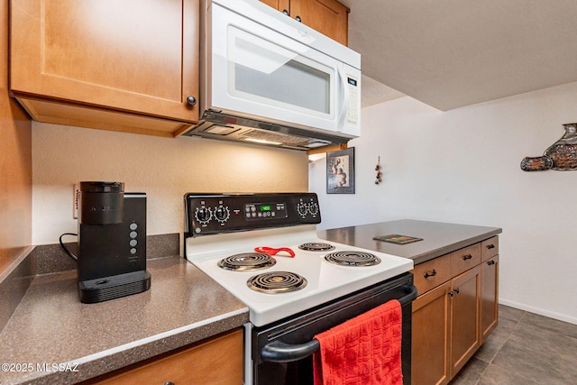 kitchen with dark tile patterned floors and range with electric cooktop