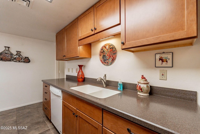 kitchen with sink, dark tile patterned floors, and dishwasher