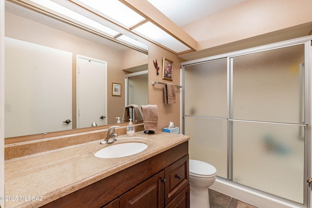 bathroom with toilet, vanity, an enclosed shower, and tile patterned floors