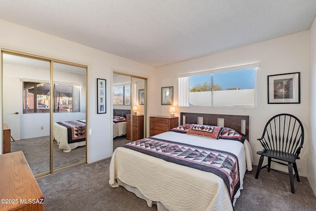 bedroom featuring multiple closets, dark carpet, and a textured ceiling