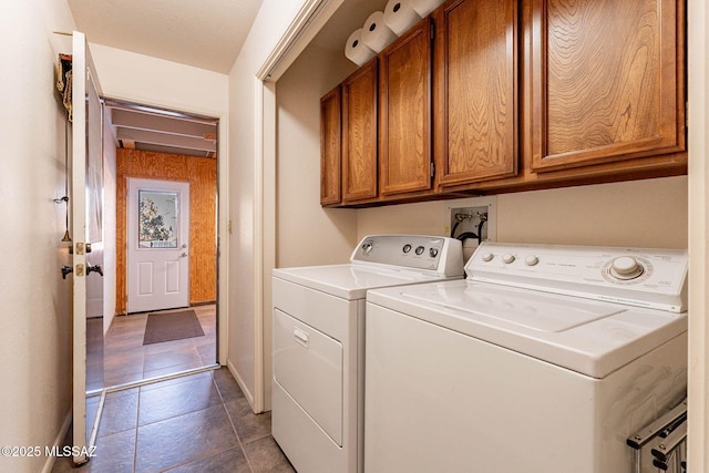 clothes washing area with washer and dryer and cabinets