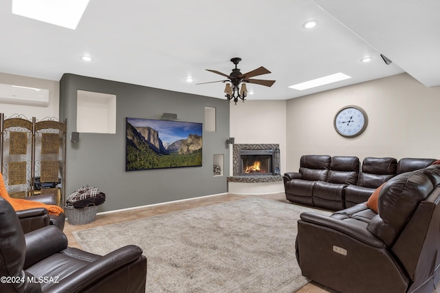 living room with a skylight, a wall unit AC, ceiling fan, tile patterned floors, and a high end fireplace