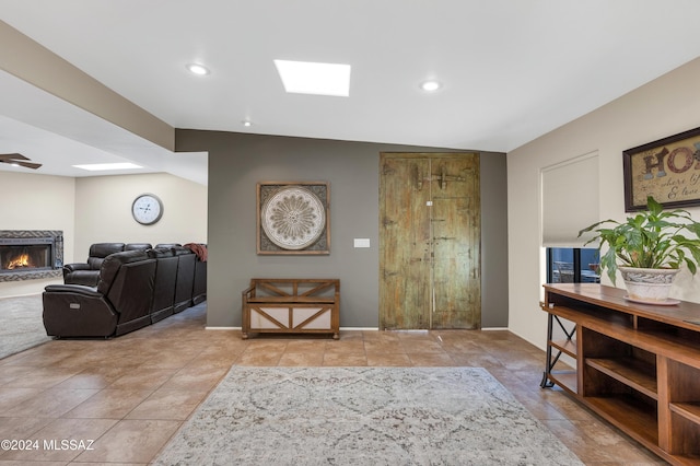 tiled foyer entrance featuring vaulted ceiling with skylight and a high end fireplace