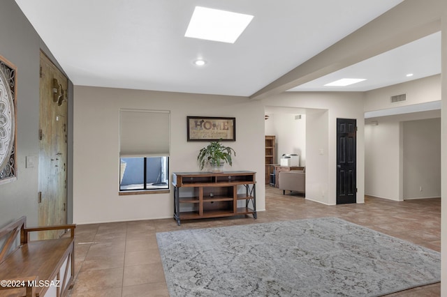 interior space with light tile patterned flooring and a skylight