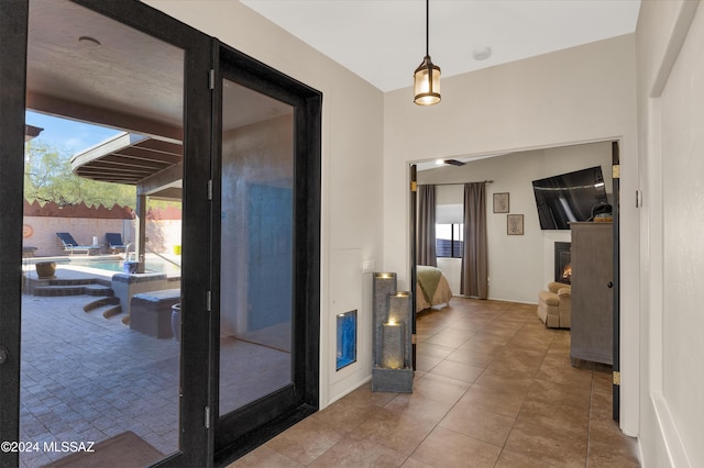 hall featuring tile patterned flooring and a healthy amount of sunlight