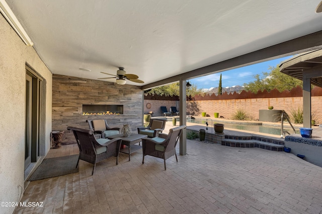 view of patio / terrace featuring ceiling fan and an outdoor fireplace