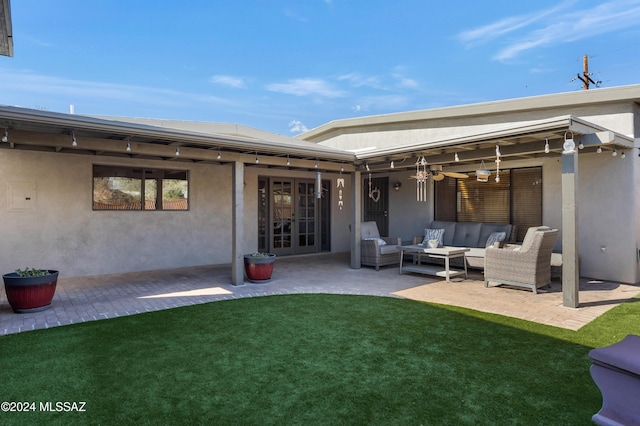 rear view of property with outdoor lounge area, a yard, french doors, and a patio