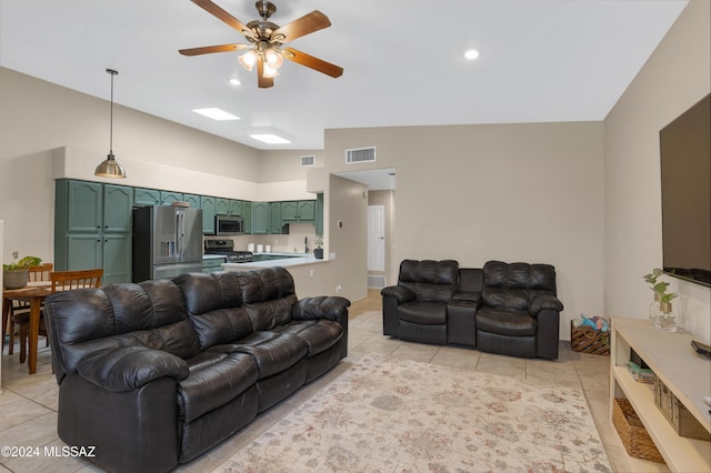 living room with ceiling fan, lofted ceiling, and light tile patterned flooring