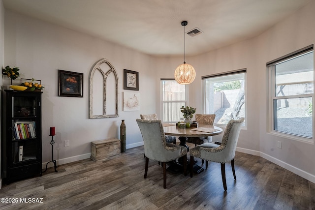 dining space with an inviting chandelier and dark hardwood / wood-style flooring