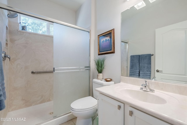 bathroom with toilet, vanity, tile patterned flooring, and a shower with shower door