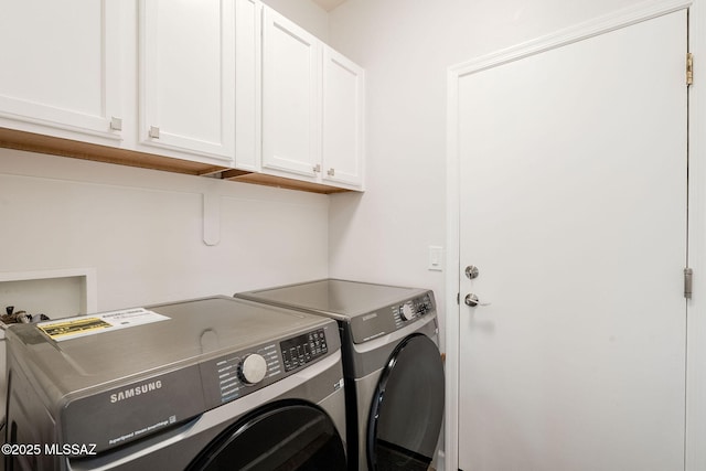 laundry room with separate washer and dryer and cabinets