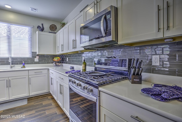 kitchen featuring sink, stainless steel appliances, white cabinets, and dark hardwood / wood-style floors