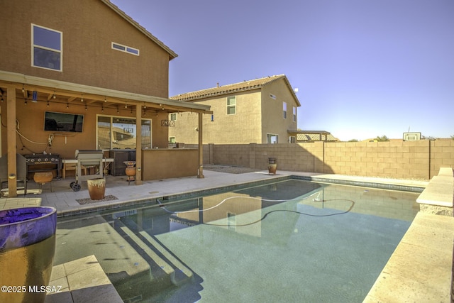 view of pool with a patio area, exterior bar, and a grill