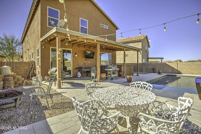 rear view of house with an outdoor fire pit, a swimming pool with hot tub, and a patio area