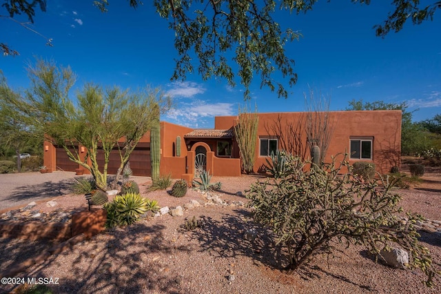 pueblo revival-style home featuring a garage