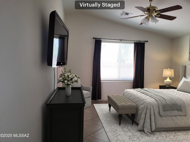 bedroom with lofted ceiling, ceiling fan, and light tile patterned floors