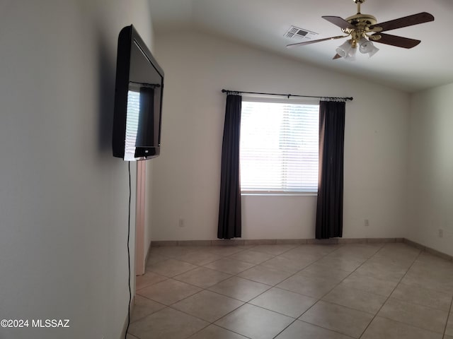 spare room featuring ceiling fan, lofted ceiling, and light tile patterned floors