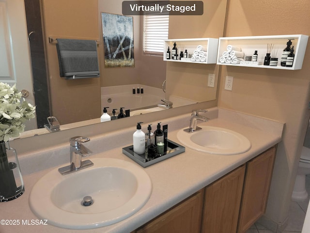 bathroom featuring toilet, vanity, and a tub to relax in