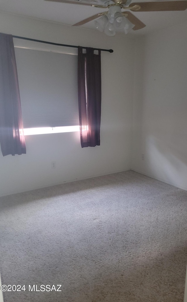 carpeted spare room with ceiling fan