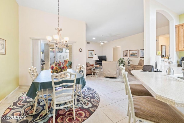 dining area featuring light tile patterned flooring and ceiling fan with notable chandelier