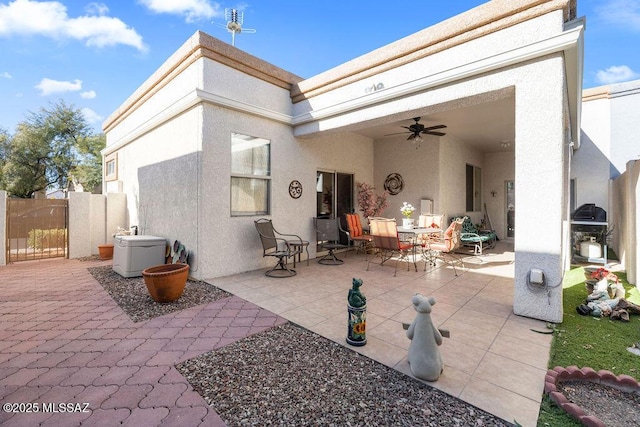 back of property with ceiling fan and a patio