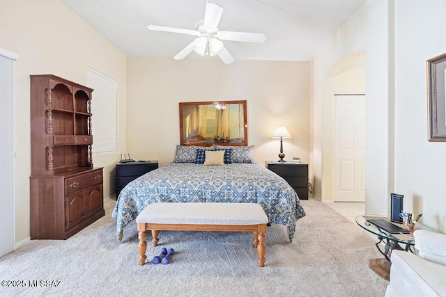 bedroom featuring light colored carpet, a closet, and ceiling fan