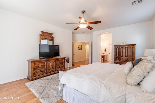 bedroom featuring ceiling fan, connected bathroom, and light wood-type flooring