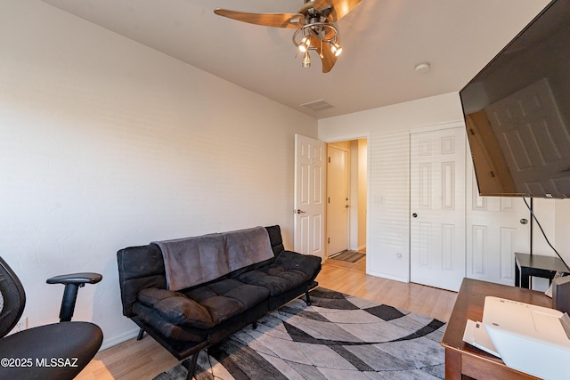 living room featuring ceiling fan and light wood-type flooring