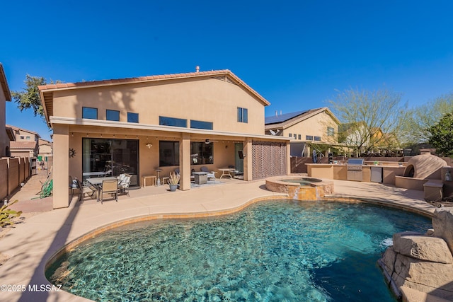 view of swimming pool featuring an in ground hot tub, exterior kitchen, and a patio area