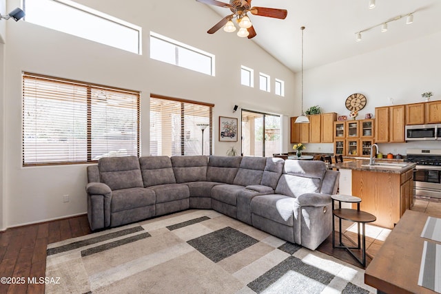 living room featuring ceiling fan, high vaulted ceiling, light hardwood / wood-style floors, and sink