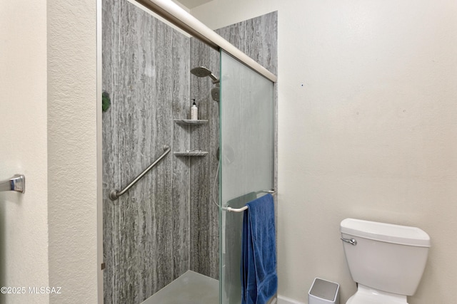 bathroom with toilet and a shower stall