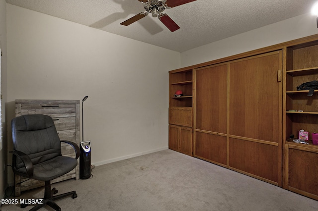 carpeted office with a ceiling fan, a textured ceiling, and baseboards