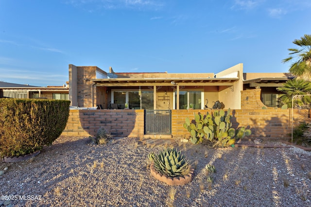 view of front of property featuring a fenced front yard, a gate, and stucco siding