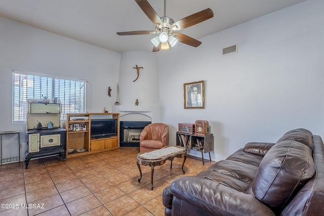 living room featuring tile patterned floors, a fireplace, and ceiling fan