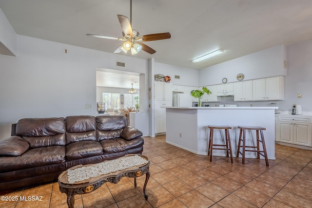 living room with ceiling fan with notable chandelier and light tile patterned floors