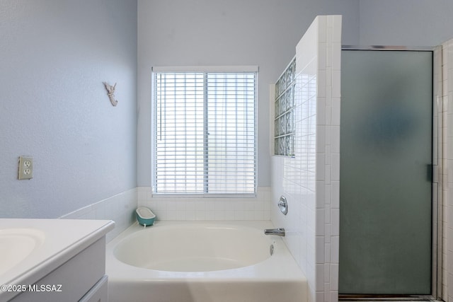 bathroom featuring shower with separate bathtub and vanity