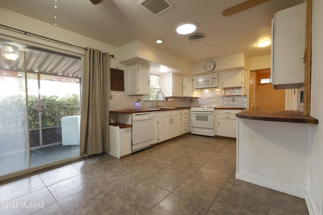 kitchen featuring sink, white appliances, a healthy amount of sunlight, and white cabinets