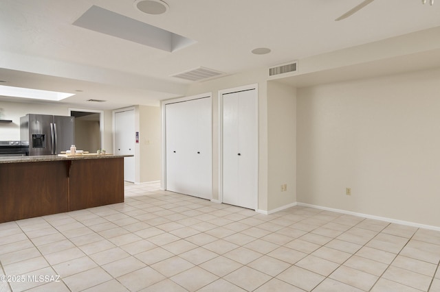 kitchen with light stone countertops, baseboards, visible vents, and stainless steel appliances