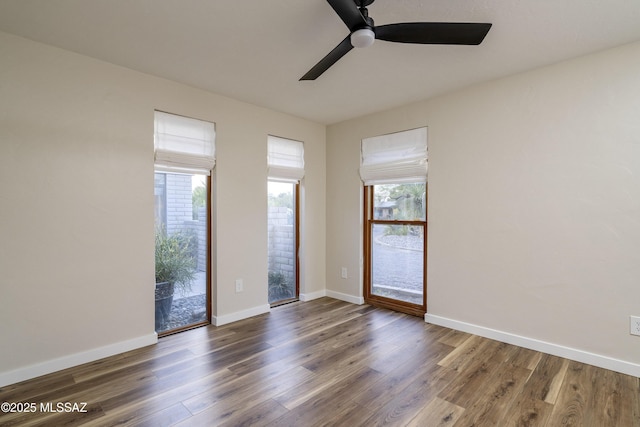 spare room with baseboards, a ceiling fan, and wood finished floors