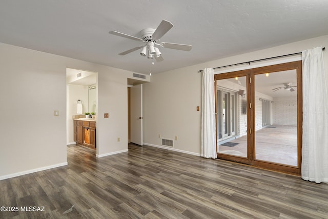 interior space featuring dark wood-type flooring, visible vents, baseboards, and a ceiling fan