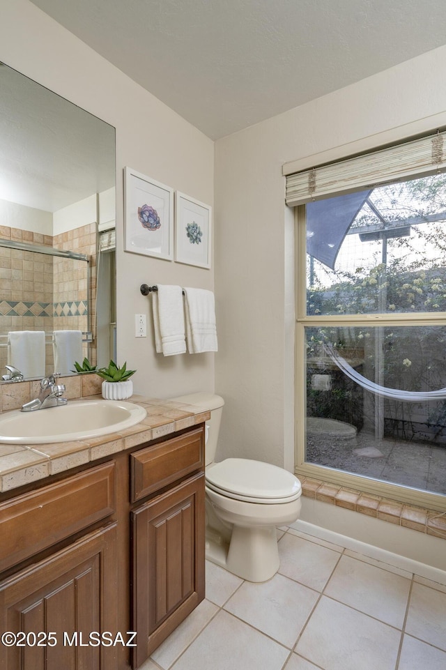 bathroom featuring tile patterned floors, vanity, walk in shower, and toilet