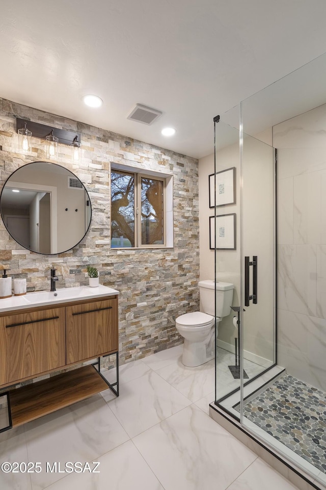 full bathroom featuring vanity, toilet, a shower stall, visible vents, and marble finish floor