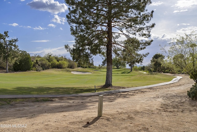 view of home's community featuring golf course view and a yard