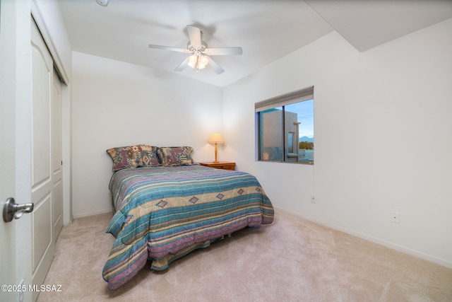 bedroom with light carpet, ceiling fan, and a closet