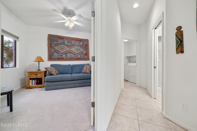 hallway featuring light tile patterned floors and washing machine and clothes dryer