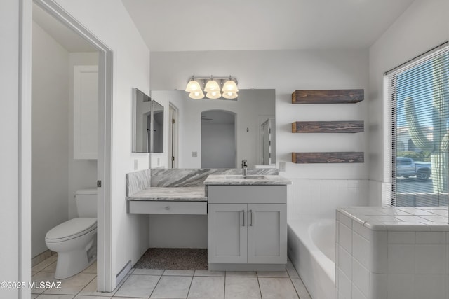 bathroom featuring a washtub, tile patterned flooring, vanity, and toilet