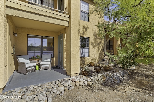 view of exterior entry featuring a balcony and a patio