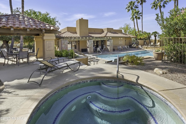 view of swimming pool featuring a community hot tub and a patio