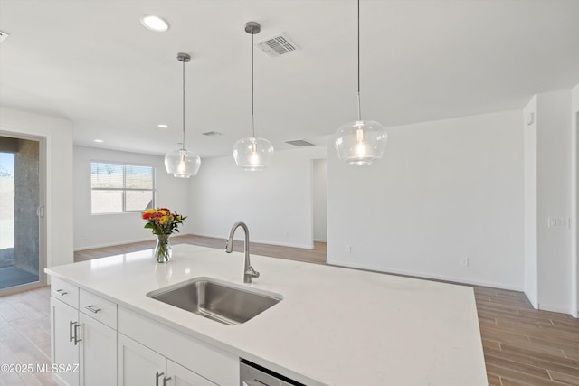 kitchen with pendant lighting, white cabinets, and sink